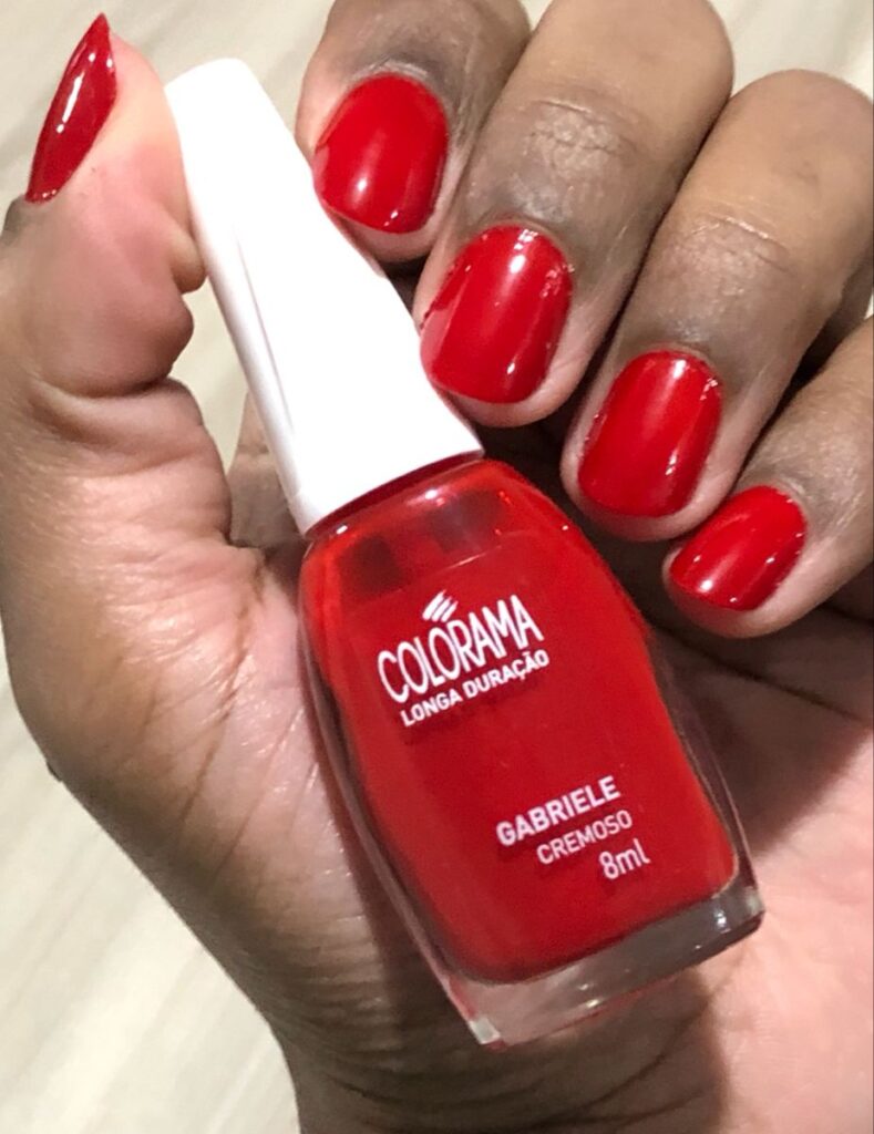 Mãos pintadas com esmalte vermelho pele negra