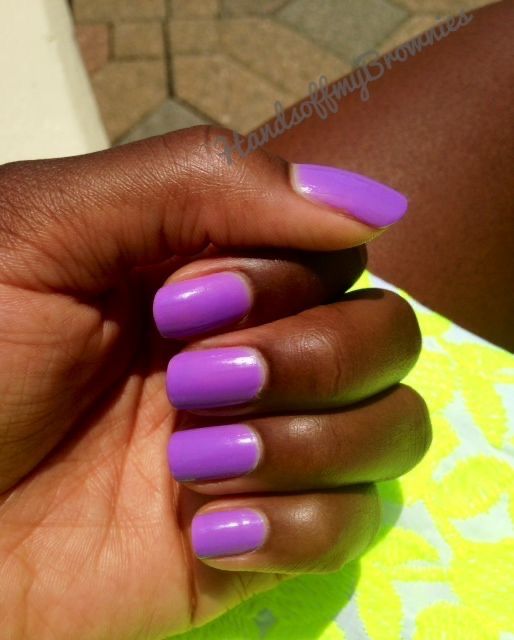 Mãos pintadas com esmalte neon roxo pele negra