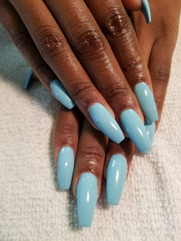 Unhas das mãos pintadas com esmalte azul claro