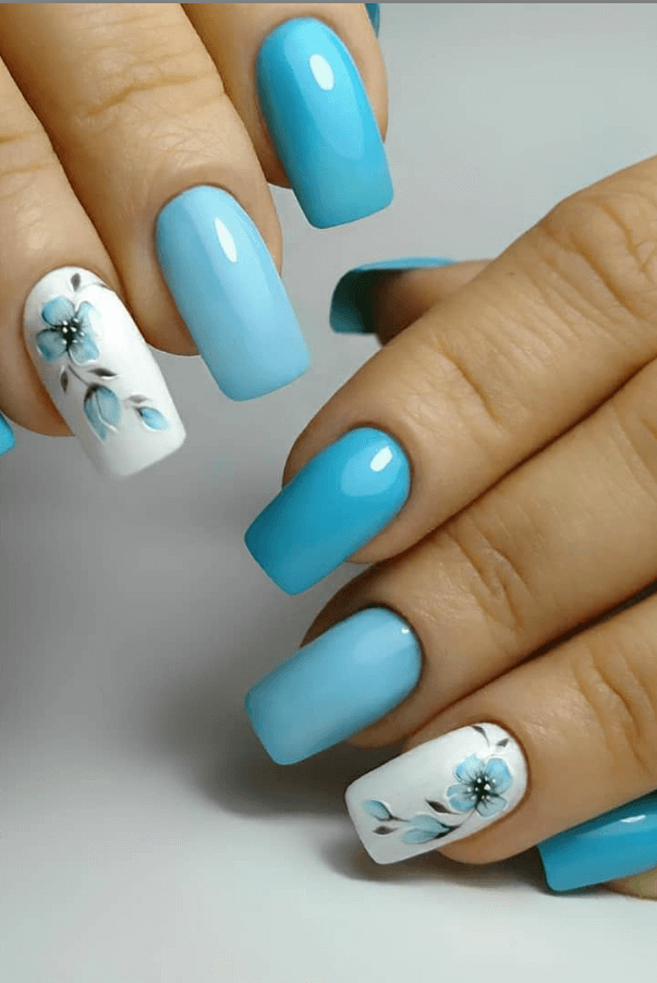 Unhas azul claro com adesivo de flores